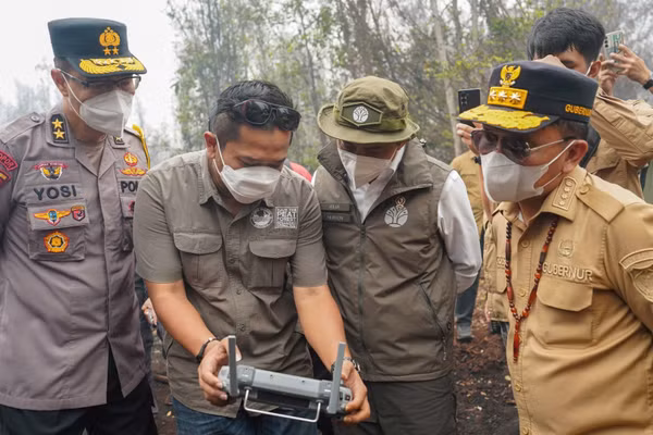 Kiểm tra thiết bị hỗ trợ chữa cháy rừng, cháy đất tại Tây Kalimantan. (Ảnh: TTXVN)