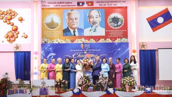 Đại sứ Việt Nam tại Lào Nguyễn Minh Tâm tặng hoa chúc mừng ngày 20/10 tại chương trình. (Ảnh: TRỊNH DŨNG)