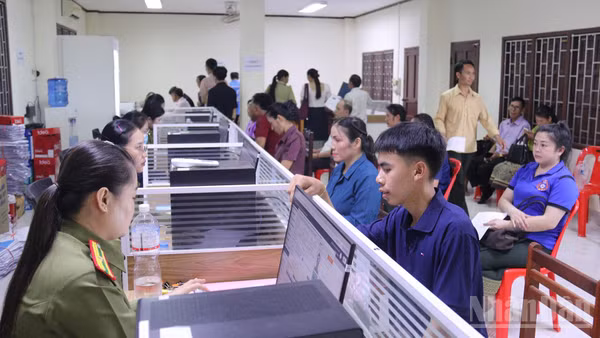 Cán bộ Cục Quản lý hộ tịch và xây dựng cơ sở, Bộ Công an Lào, hướng dẫn người dân Lào làm thủ tục căn cước công dân. (Ảnh: DUY TOÀN)