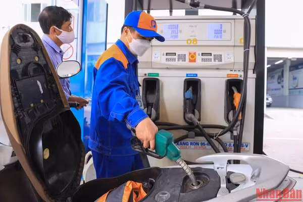 Nhân viên bơm xăng cho khách hàng tại một cửa hàng kinh doanh xăng dầu. (Ảnh: THÀNH ĐẠT)