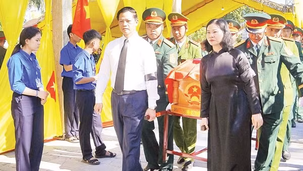 Các đại biểu tiễn đưa các liệt sĩ về nơi an nghỉ (Ảnh HIẾU MINH)