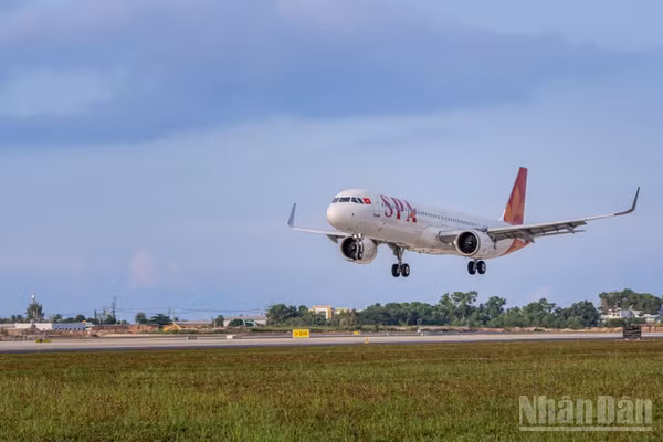 Vào lúc 7 giờ 5 phút, chuyến bay 9G1955 của Sun PhuQuoc Airways hạ cánh, trở thành chuyến bay thương mại đầu tiên trên đường cất hạ cánh mới. (Ảnh: ÁNH DƯƠNG)