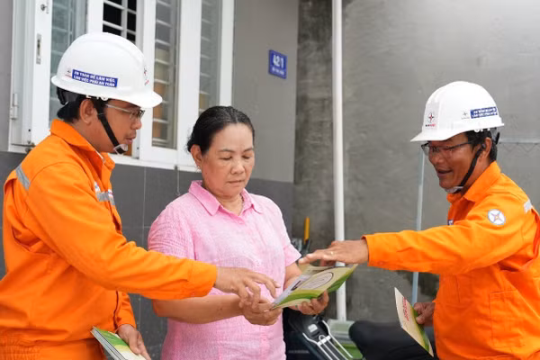 Nhân viên Công ty Điện lực Đất Đỏ trực tiếp tuyên truyền, hướng dẫn người dân các biện pháp sử dụng điện an toàn trong mùa mưa bão. (Ảnh: DUY ĐOÀN)