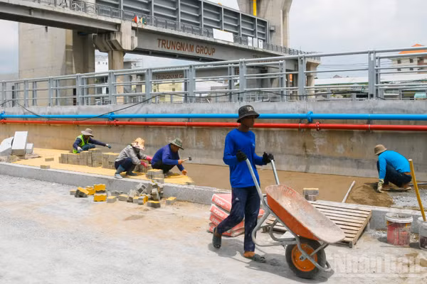 Công nhân hối hả thi công tại cống ngăn triều Phú Định. (Ảnh: QUANG QUÝ)