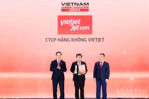 Ông Thái Trọng Cang, Kế toán trưởng Vietjet (đứng giữa) nhận bằng khen và cúp vinh danh doanh nghiệp dẫn đầu nhóm doanh nghiệp hàng không, logistics tư nhân nộp ngân sách lớn nhất Việt Nam năm 2025. (Ảnh: BẢO VY)