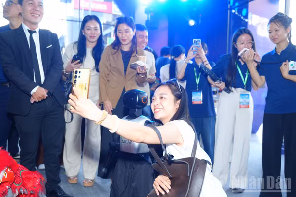 Các đại biểu chụp hình cùng robot tại sự kiện. (Ảnh: CTV)