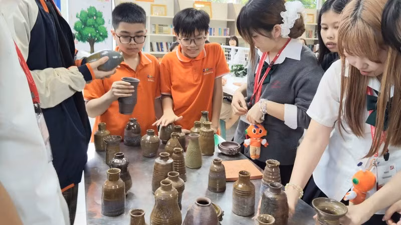 Các em nhỏ tham gia trải nghiệm làm nghề thủ công truyền thống. 