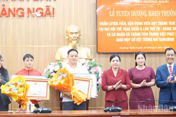 Phó Chủ tịch Thường trực Ủy ban nhân dân tỉnh Quảng Ngãi Y Ngọc cùng lãnh đạo Sở Văn hóa, Thể thao và Du lịch tỉnh Quảng Ngãi trao Bằng khen và tặng hoa chúc mừng vận động viên Đinh Văn Tâm và huấn luyện viên Phạm Quốc Anh. (Ảnh: HIỂN CỪ)