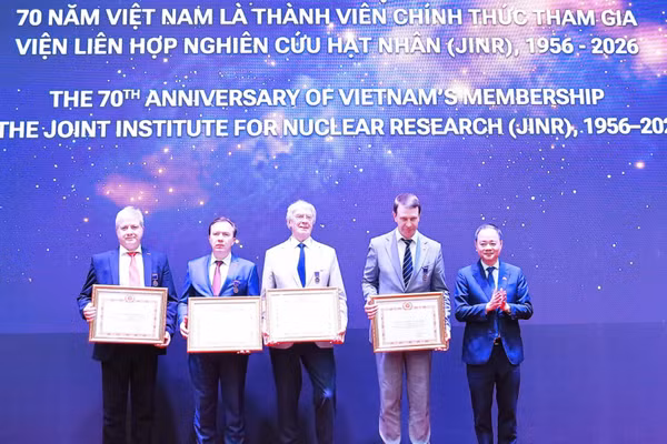 Giáo sư, Tiến sĩ Trần Hồng Thái, Ủy viên Trung ương Đảng, Chủ tịch Viện Hàn lâm Khoa học và Công nghệ Việt Nam trao tặng kỷ niệm chương vinh danh các nhà lãnh đạo, các nhà khoa học xuất sắc của JINR. (Ảnh: XUÂN KỲ)