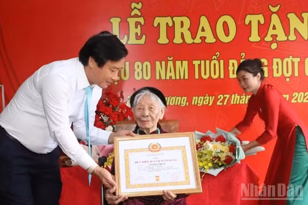 Phó Bí thư Tỉnh ủy Phú Thọ Nguyễn Mạnh Sơn gắn Huy hiệu 80 năm tuổi Đảng cho đảng viên Vương Thị Sỹ, Đảng bộ xã Hoàng Cương. (Ảnh: Ngọc Long)