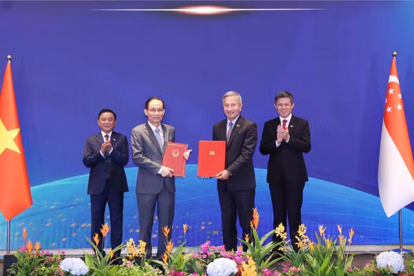 Ủy viên Bộ Chính trị, Bộ trưởng Ngoại giao Lê Hoài Trung và Bộ trưởng Ngoại giao Singapore Vivian Balakrishnan trao Bản ghi nhớ hợp tác giữa hai Đảng. (Ảnh: Phương Hoa/TTXVN)