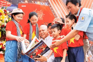 Nghệ sĩ nhiếp ảnh Nguyễn Á (áo trắng) giới thiệu sách ảnh tới công chúng.