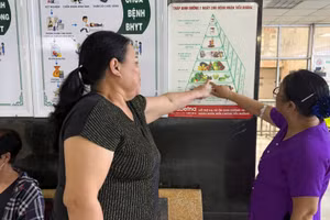 Người dân tìm hiểu thông tin về chế độ dinh dưỡng dành cho người mắc các bệnh không lây nhiễm tại cơ sở khám, chữa bệnh. (Ảnh: VÂN VÂN)
