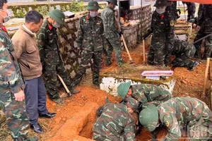 Lực lượng chức năng tiến hành quy tập các hài cốt liệt sĩ. (Ảnh: ĐAM TRỌNG)