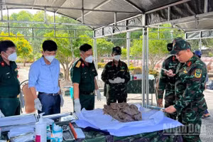 Lấy mẫu hài cốt liệt sĩ phục vụ giám định ADN tại Nghĩa trang Liệt sĩ Bến Tre. (Ảnh: HOÀNG TRUNG)