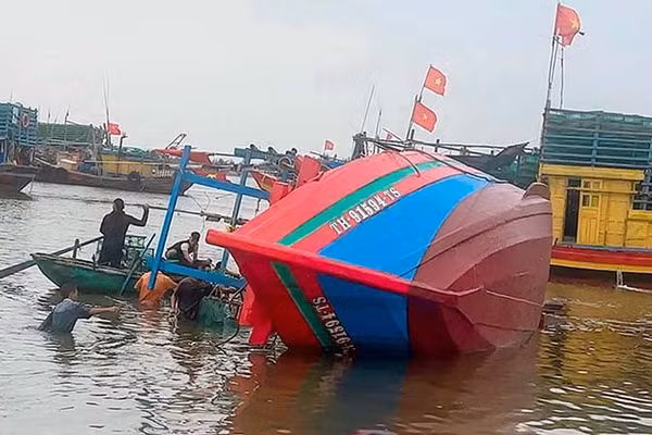 Nhân dân cùng Bộ đội Biên phòng cứu hộ tàu cá bị chìm cho chủ sở hữu phương tiện. (Ảnh: Bộ đội Biên phòng Thanh Hóa)