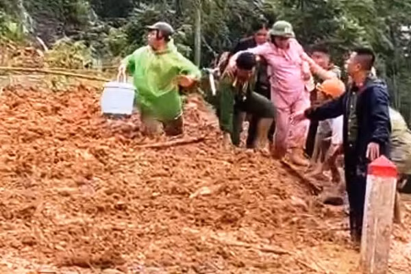 Công an hỗ trợ sản phụ vượt qua điểm tắc đường do sạt lở. (Ảnh: Công an Thanh Hóa)