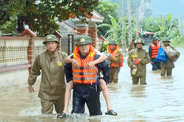 Công an xã Cẩm Tú giúp dân di chuyển người, đồ dùng khỏi khu vực bị ngập nước. (Ảnh: Công an Thanh Hóa)