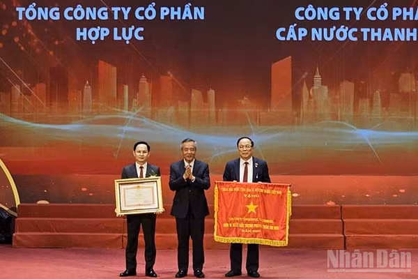 Hai doanh nghiệp tiêu biểu của tỉnh Thanh Hóa vinh dự đón Cờ thi đua và Bằng khen của Thủ tướng Chính phủ. (Ảnh: MAI LUẬN)