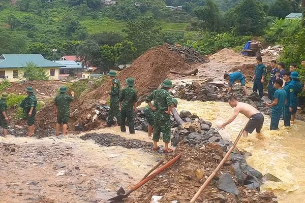 Lực lượng vũ trang ở xã Trung Lý nắn dòng chảy bảo vệ khu dân cư, cây trồng, giảm thiệt hại và khai thác công năng đường giao thông. (Ảnh: Bộ đội Biên phòng Thanh Hóa)