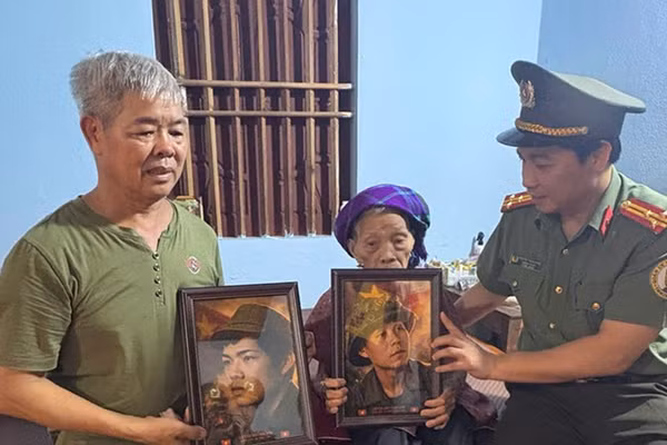 Đại diện đoàn công tác trao ảnh liệt sĩ phục dựng cho gia đình Bà mẹ Việt Nam Anh hùng.