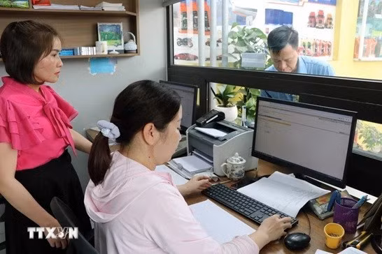 Hoạt động xuất hóa đơn điện tử tại cửa hàng. (Ảnh: Hoàng Ngọc/TTXVN)