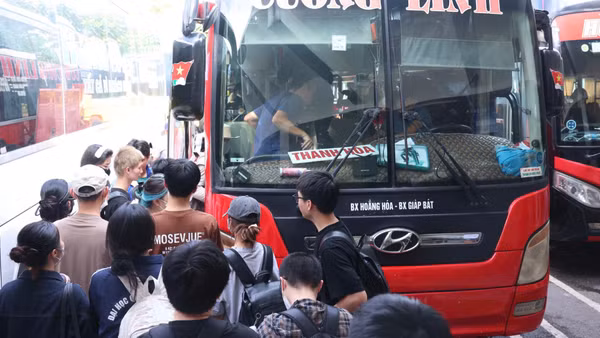 Hành khách lên xe về quê nghỉ lễ tại bến xe Giáp Bát, Hà Nội (Ảnh: HÙNG KHÁNH)