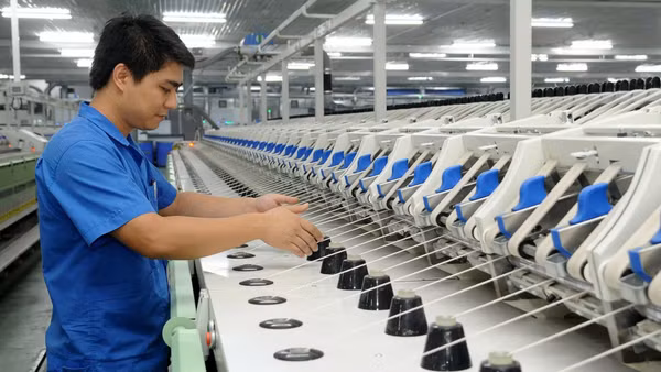 Công nhân Công ty trách nhiệm hữu hạn Một thành viên Dệt 8-3 vận hành dây chuyền sản xuất sợi. (Ảnh: TRẦN HẢI)