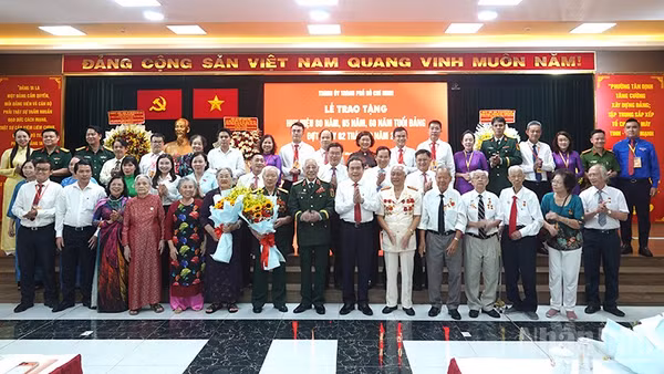 Chủ tịch Quốc hội Trần Thanh Mẫn chụp ảnh lưu niệm với các đại biểu, đảng viên lão thành. (Ảnh: Linh Bảo)