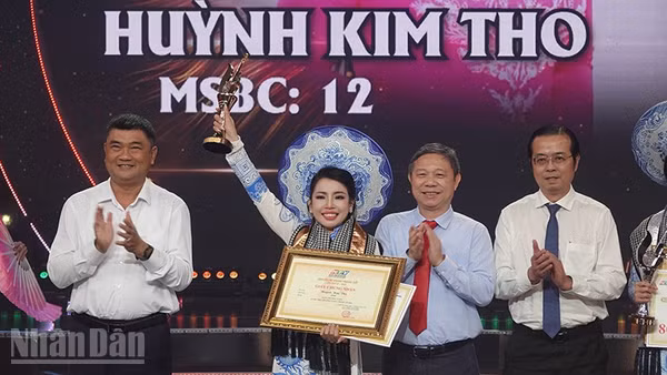 Trung tướng Lê Xuân Thế (bìa trái), Ủy viên Trung ương Đảng, Ủy viên Quân ủy Trung ương, Phó Bí thư Đảng ủy, Tư lệnh Quân khu 7; Trưởng Ban Tuyên giáo Thành ủy Dương Anh Đức và Tổng Giám đốc Cơ quan Báo và Phát thanh, Truyền hình Thành phố Lê Văn Minh trao Chuông Vàng cho thí sinh Huỳnh Kim Tho. (Ảnh: LINH BẢO)