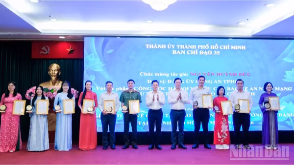 Đồng chí Lê Quốc Phong, Phó Bí thư Thường trực Thành ủy Thành phố Hồ Chí Minh (thứ 5 từ phải qua), đồng chí Nguyễn Huy Ngọc, Vụ trưởng Vụ Địa phương 3, Ban Tuyên giáo Trung ương trao giải cho các tác giả đoạt giải ở thể loại tạp chí. (Ảnh: THẾ ANH)