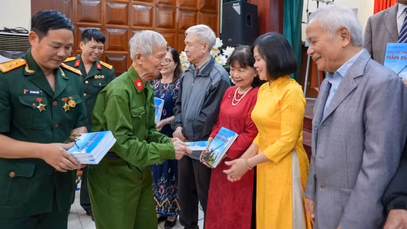 Thương binh, nhà giáo Nguyễn Thùy (hàng trên, thứ hai từ trái qua) trao tặng bạn đọc nhật ký thời chiến.