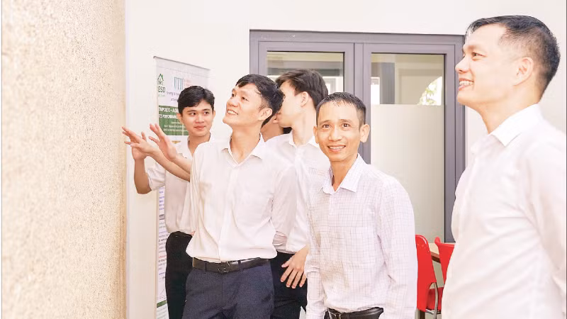 Giảng viên và sinh viên Trường đại học Giao thông vận tải Thành phố Hồ Chí Minh bên bức tường bê-tông gai dầu.