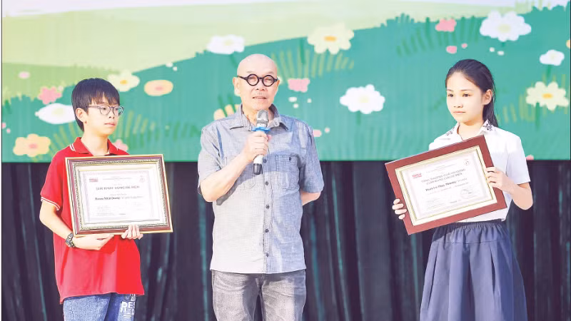 Họa sĩ Thành Chương chia sẻ niềm vui với các tác giả nhí nhận Giải thưởng Thiếu nhi Dế Mèn. (Ảnh: MAI AN)