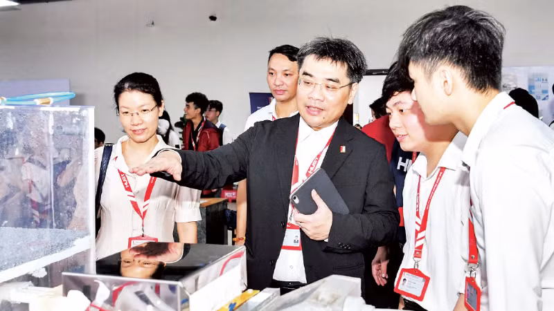 Lãnh đạo Đại học Bách khoa Hà Nội trao đổi với sinh viên về sản phẩm nghiên cứu khoa học tại một triển lãm.