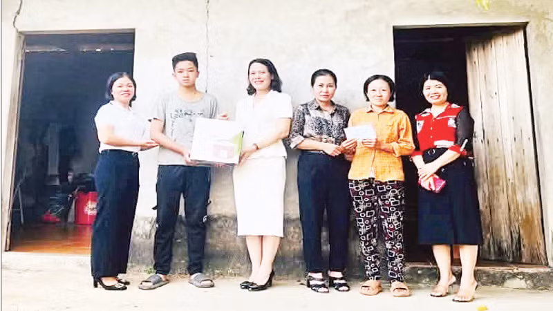 Thầy, cô giáo Trường trung học phổ thông Tam Đảo trao quà, đồ dùng học tập tặng em Trần Văn Thiên.