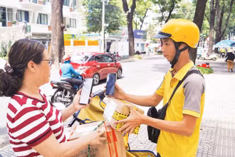 Khách hàng thanh toán không tiền mặt khi nhận hàng hóa trên đường Phạm Ngọc Thạch, Quận 3. (Ảnh THẾ ANH)