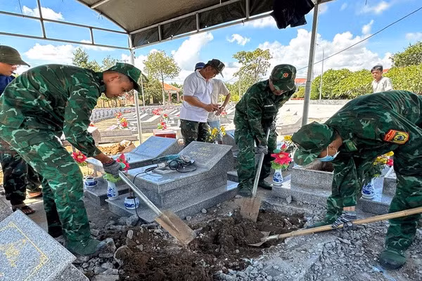 Cán bộ, chiến sĩ Đồn Biên phòng Cửa khẩu cảng Giao Long thực hiện việc cất bốc, quy tập hài cốt liệt sĩ chưa xác định danh tính. (Ảnh: HOÀNG TRUNG)