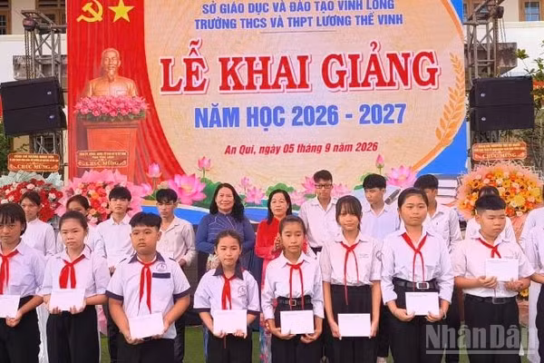 Lãnh đạo tỉnh Vĩnh Long tặng quà học sinh có hoàn cảnh khó khăn tại Trường trung học cơ sở, trung học phổ thông Lương Thế Vinh. (Ảnh: HOÀNG TRUNG)
