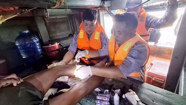 Cán bộ, chiến sĩ Cảnh sát biển tiến hành băng bó vết thương và cầm máu cho ngư dân gặp nạn. (Ảnh: Bộ Tư lệnh Vùng Cảnh sát biển 4)