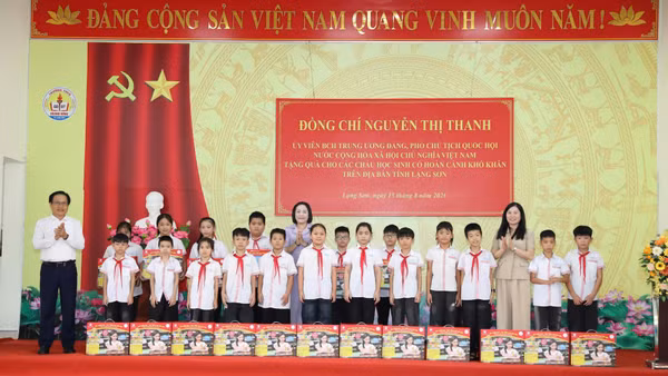 Đồng chí Phó Chủ tịch Quốc hội và lãnh đạo tỉnh Lạng Sơn tặng quà cho học sinh. (Ảnh: VĂN ĐẠT)
