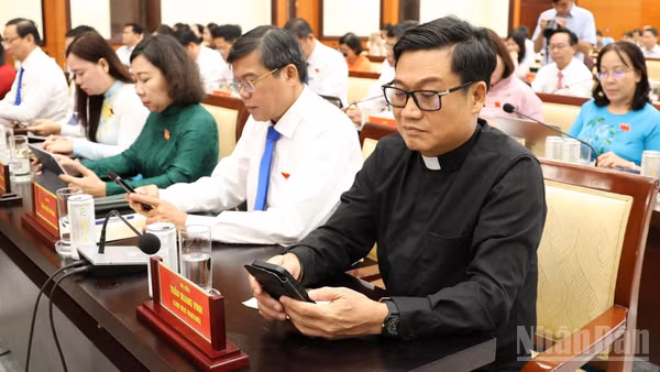 Các đại biểu nhấn nút thông qua Đề án thành lập các phường trên cơ sở nguyên trạng 29 xã trên địa bàn thành phố. (Ảnh: THẾ ANH)