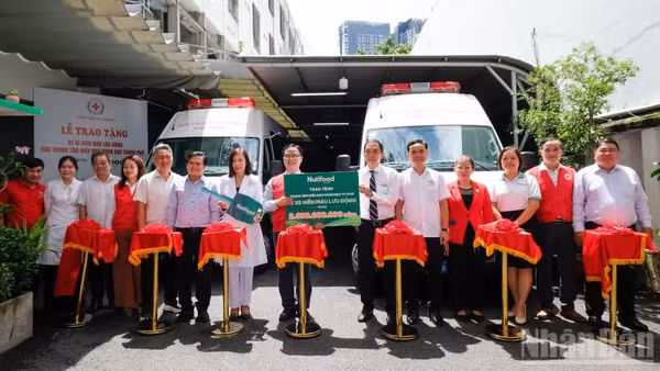 Nghi thức bàn giao 2 xe hiến máu lưu động cho Trung tâm Hiến máu nhân đạo thành phố. (Ảnh: THẾ ANH) 