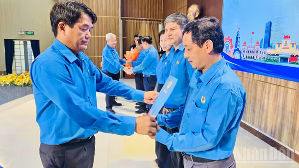 Ông Bùi Thanh Nhân, Chủ tịch Liên đoàn Lao động Thành phố Hồ Chí Minh trao quyết định thành lập các Công đoàn khu công nghiệp cho các cán bộ công đoàn. (Ảnh: VƯƠNG LÊ) 