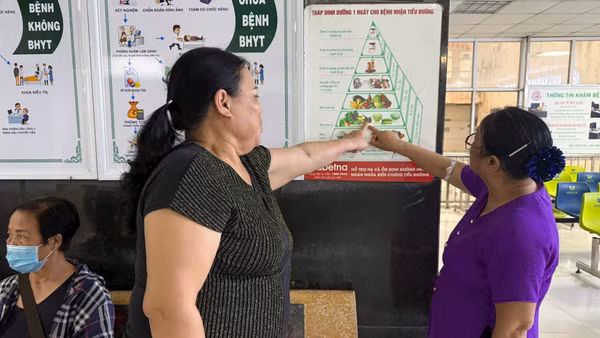 Người dân tìm hiểu thông tin về chế độ dinh dưỡng dành cho người mắc các bệnh không lây nhiễm tại cơ sở khám, chữa bệnh. (Ảnh: VÂN VÂN)