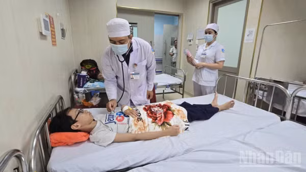Bác sĩ của Bệnh viện Sản nhi tỉnh khám, điều trị 1 ca mắc bệnh sốt xuất huyết. (Ảnh: THANH DŨNG)