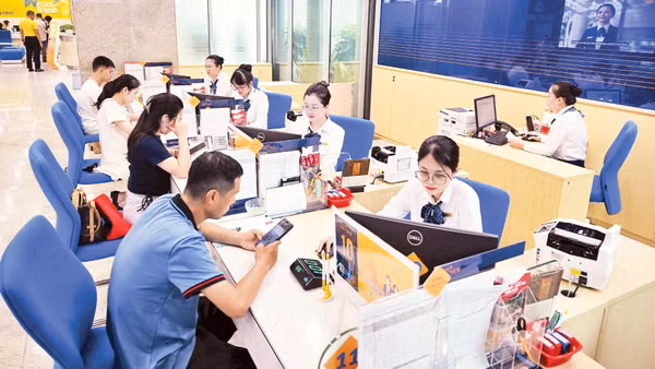 Khách hàng giao dịch tại Ngân hàng PVcomBank. (Ảnh: TRẦN HẢI)