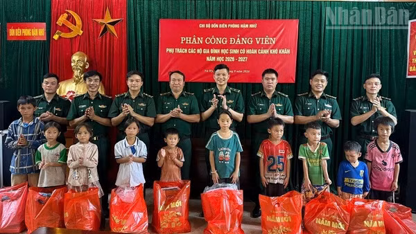 Các đảng viên Đồn Biên phòng Nậm Nhừ tổ chức gặp gỡ, trao quà, động viên các cháu học sinh con hộ nghèo, hoàn cảnh khó khăn đang được giúp đỡ theo mô hình "Bố, mẹ đỡ đầu". (Ảnh: LÊ LAN)