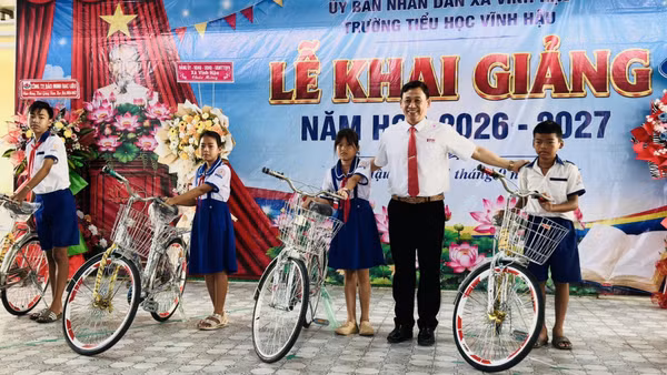 Đồng chí Trần Hoàng Khải, Chủ tịch Ủy ban nhân dân xã Vĩnh Hậu (Cà Mau), trao tặng xe đạp cho các em học sinh nghèo vùng ven biển, học sinh dân tộc Khmer trong xã. (Ảnh: ĐẶNG THẾ VĨNH)