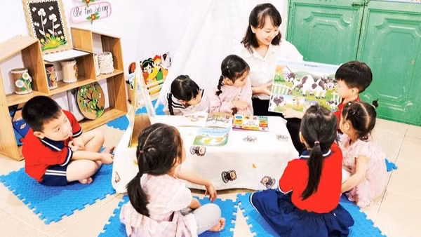 Cô và trò làm quen với sách trước năm học thí điểm Chương trình giáo dục mầm non mới. (Ảnh: THU TRANG)